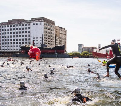 Individuals jumping into River Thames as part of the London Triathlon