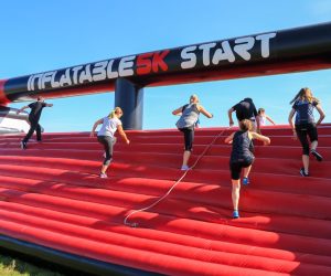 Runners on an inflatable course with the words 'Inflatable 5k Start'